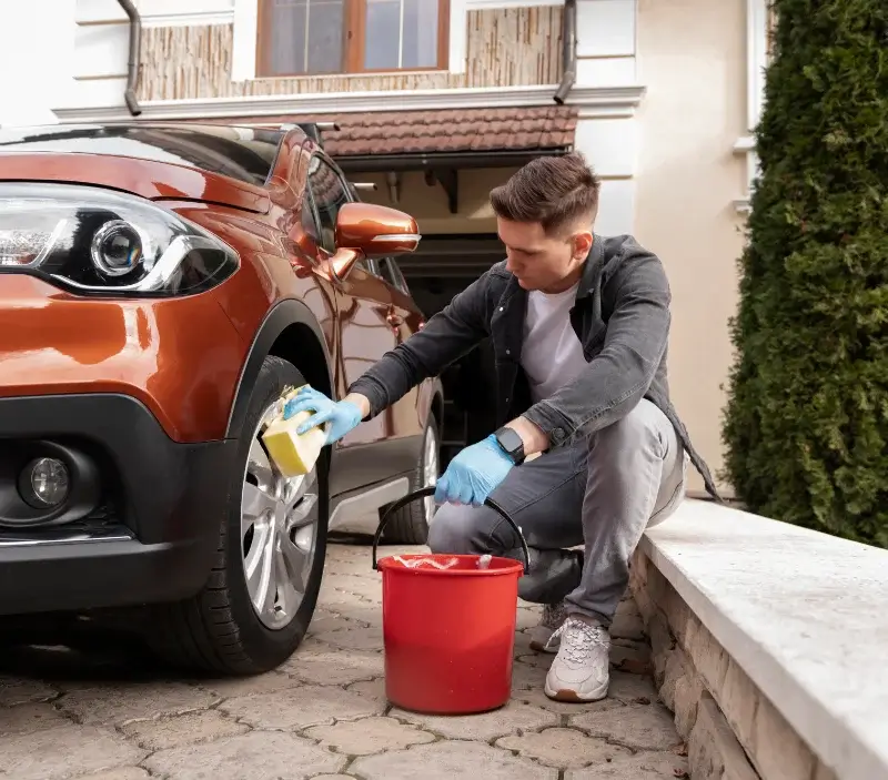Lavage auto à domicile Châteauneuf-la-Forêt : professionnel intervenant sur un véhicule